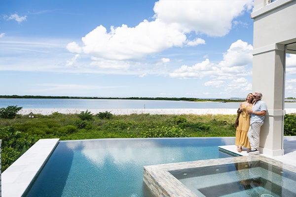 Couple on pool deck with beach views