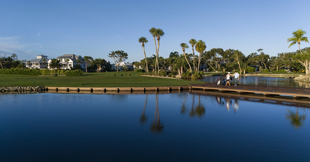 Homes overlooking a golf course with lakes and palm trees