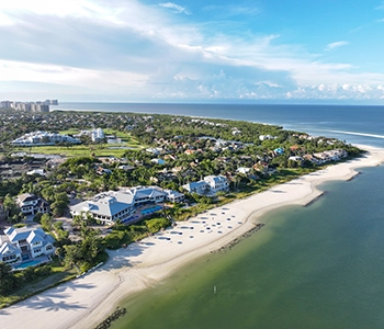 An aerial view of Hideaway Beach Club showing private beachfront homes, lush landscaping, and the Gulf of Mexico.