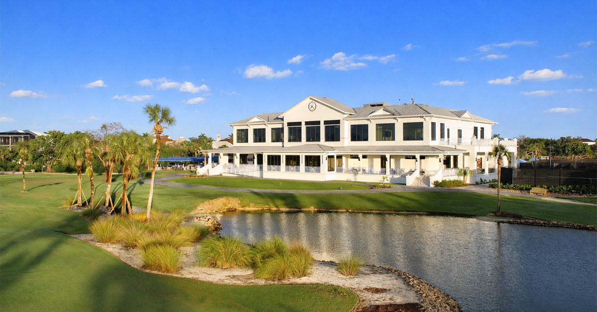 Resort main house beside water and lawn.